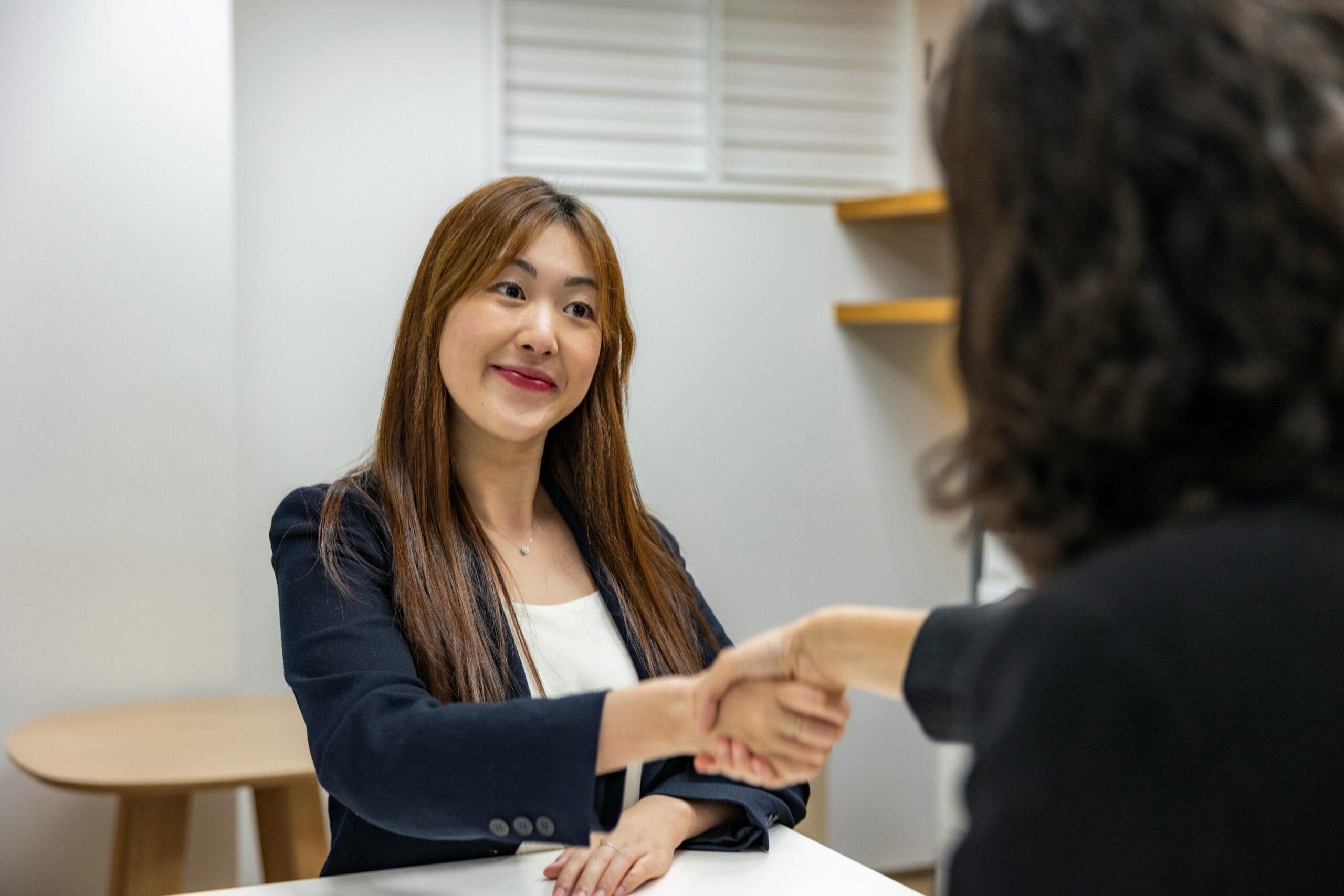 young woman in business attire shaking hands